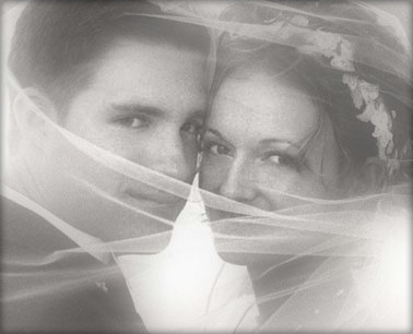 black and white image of bride and groom covered with bride's veil - testimonials photo