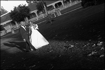 bride and groom strolling hand-in-hand with long shadows 