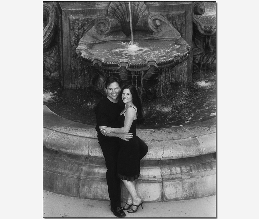 couple smiling on a fountain 