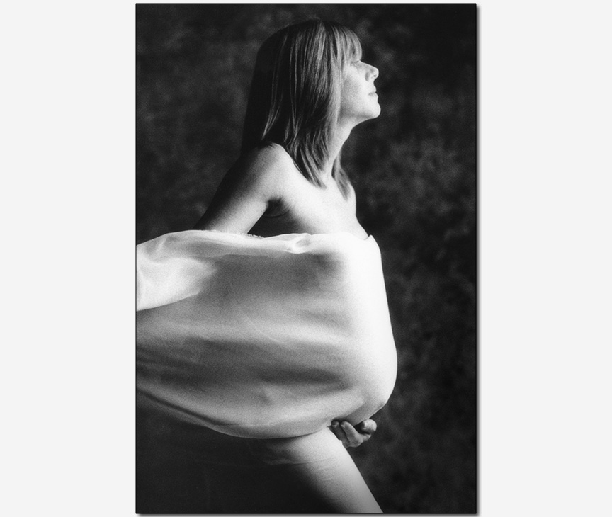 pregnant woman wrapped in cloth caressed by wind